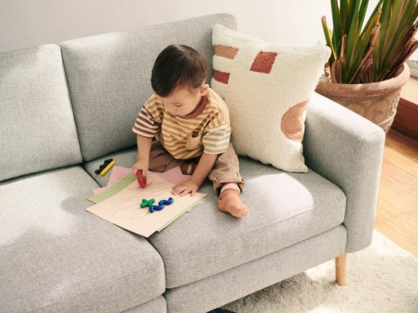 baby sitting on a Nomad sofa coloring