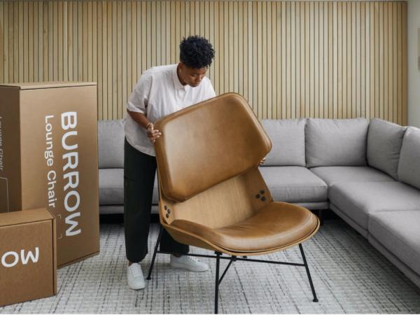 Man putting the back of the chair onto the base
