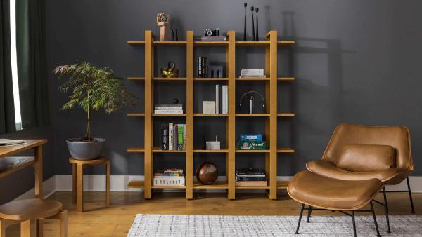 Image of a living room with a leather chair and ottoman with wooden shelves