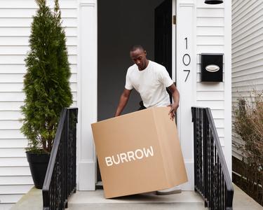 Customer receiving Burrow furniture in boxes delivered to his front door