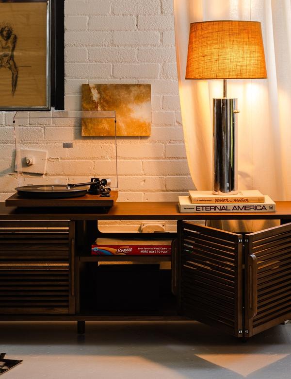 Opera media console in walnut with a record player and table lamp