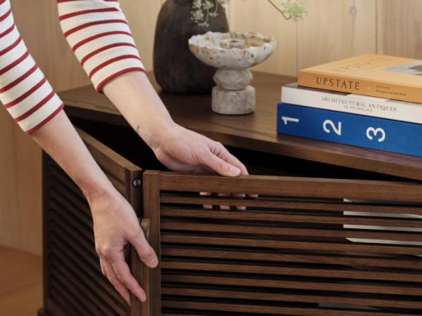 Photo of hands opening wood cabinet with slats