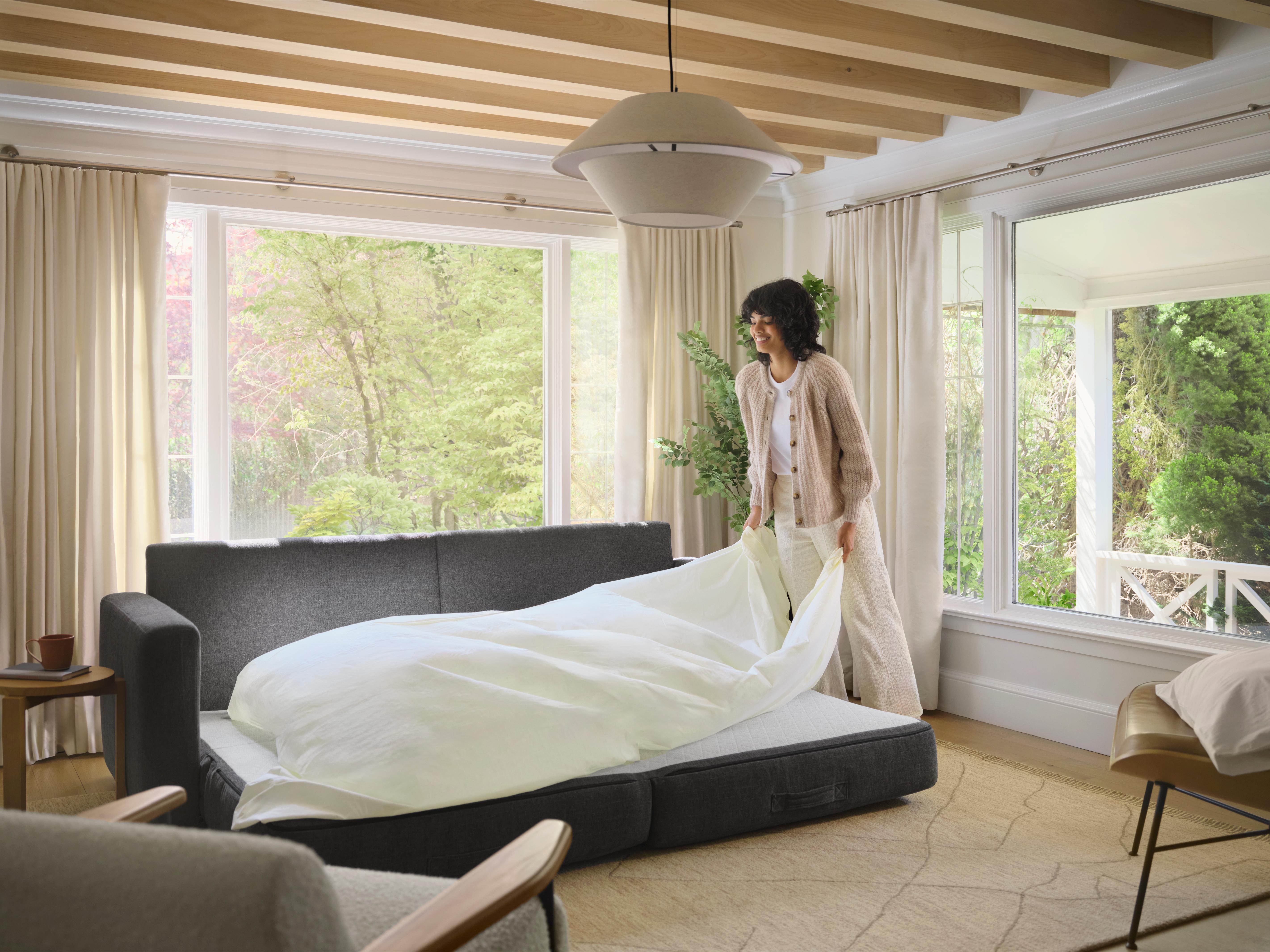 woman turning sleeper sofa into a bed