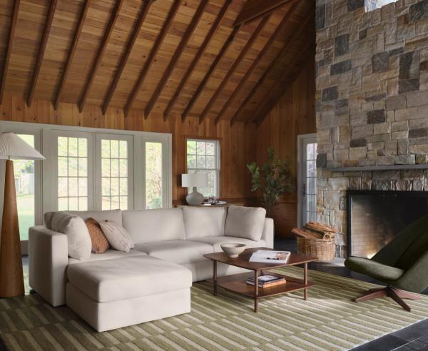 3-piece sofa with ottoman and walnut coffee table on green striped rug