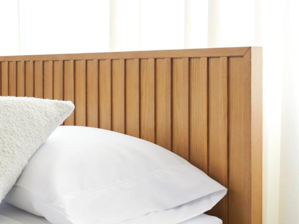 closeup of chorus headboard with some pillows on the bed
