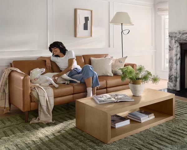 woman and dog on nomad plus leather with cassette coffee table