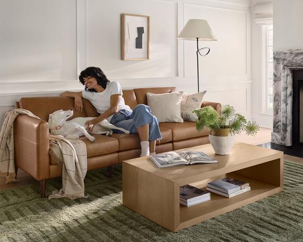 woman and dog on nomad plus leather with cassette coffee table