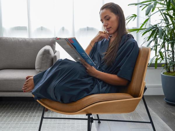 Woman curled up reading in brown leather chair