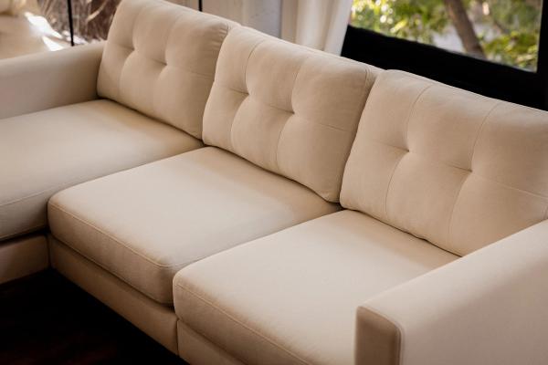Close-up of ivory Nomad sectional with tufted back cushions