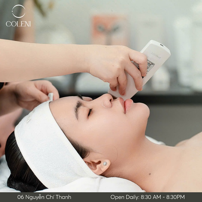 A woman receives a facial treatment using a handheld device.