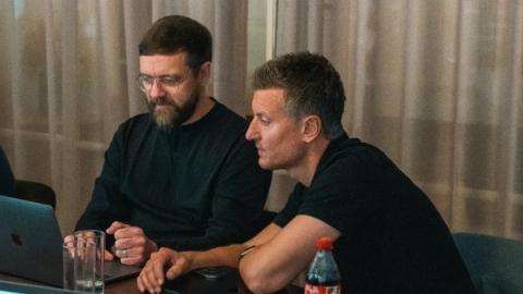Two colleagues working together at a laptop during UNRVLD's AI workshop.