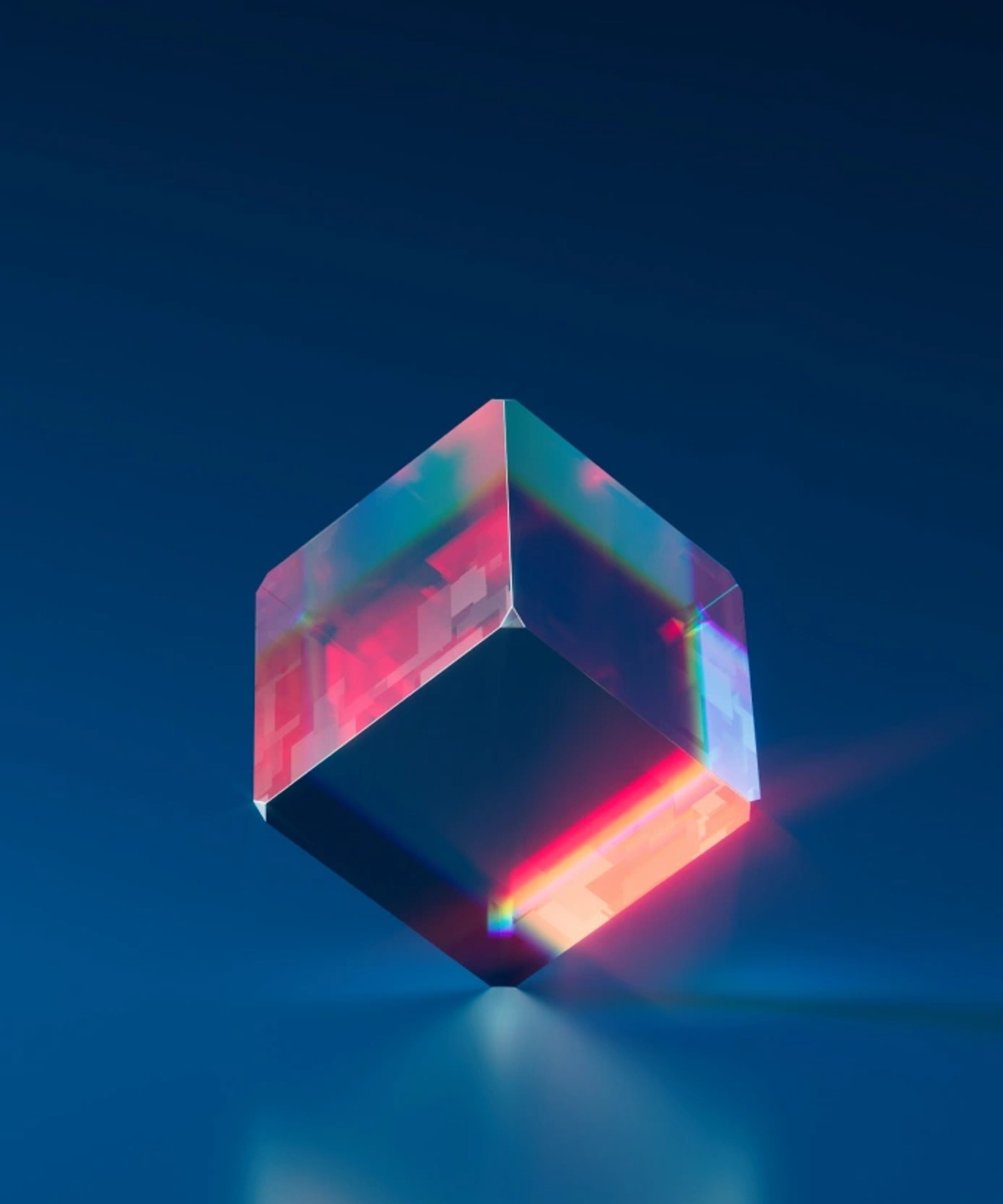 Translucent glass cube refracting pink and red light against a deep blue background.