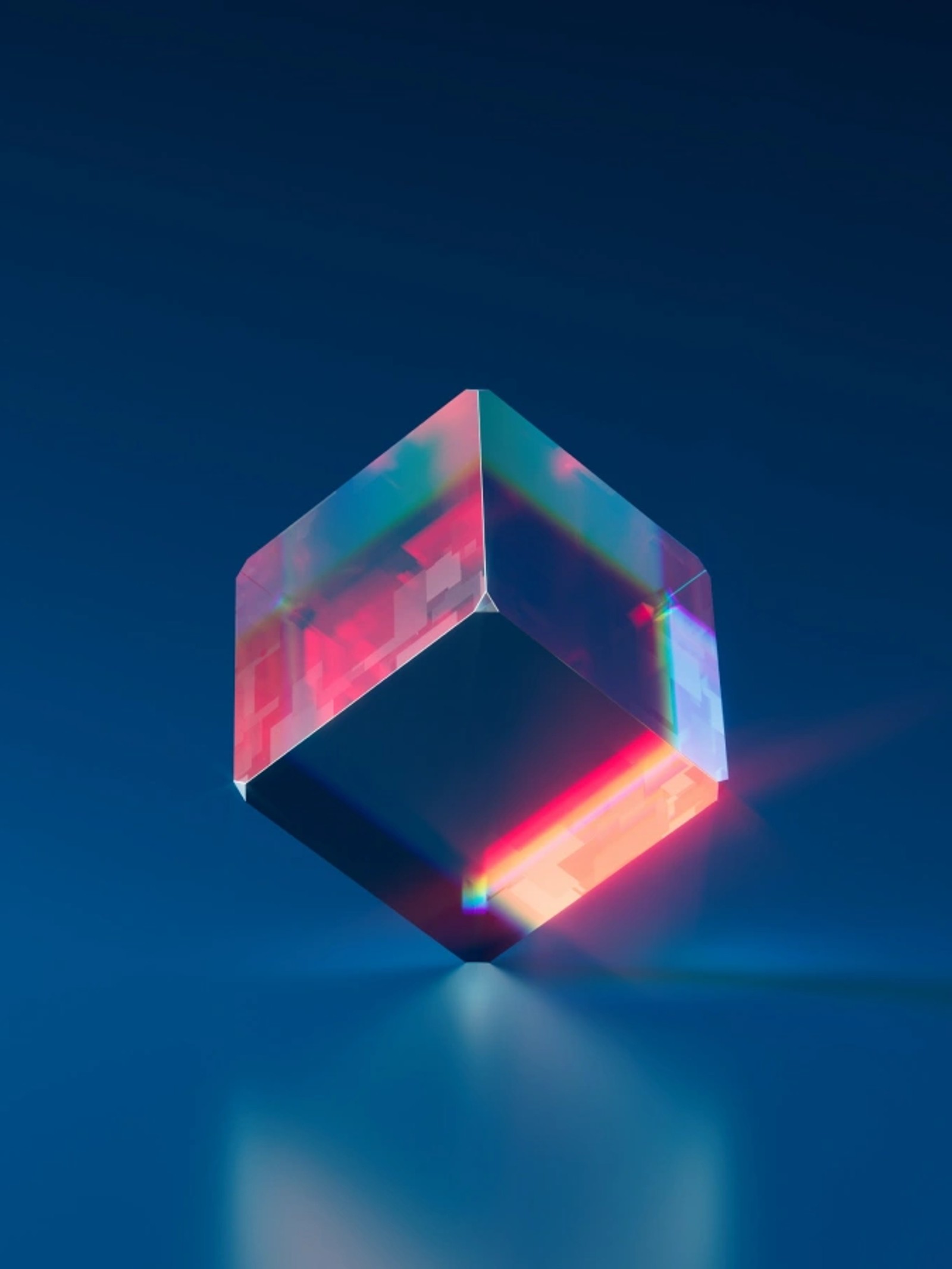 Translucent glass cube refracting pink and red light against a deep blue background.