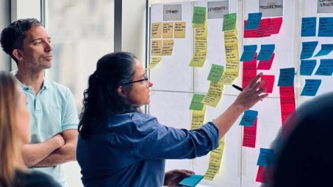 Woman placing post-it notes on wall