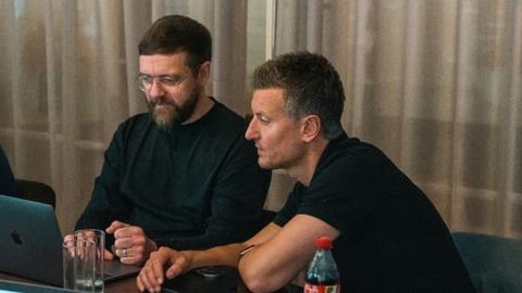 Two colleagues working together at a laptop during a meeting.