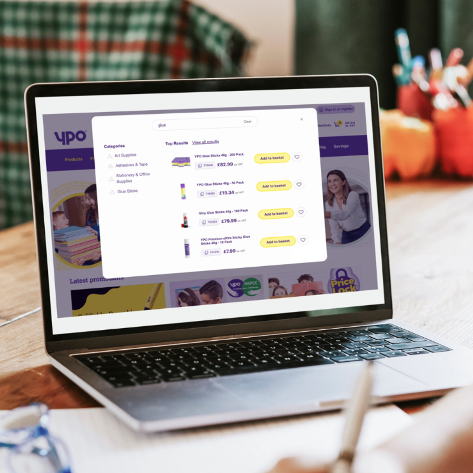 A laptop screen showing the YPO commerce site with product search results, category navigation, and pricing - representing a digital procurement experience for public sector buyers.