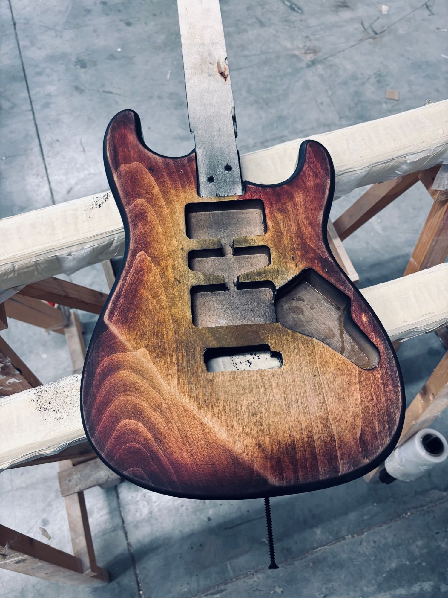 A De Gattis guitar body with its sunburst finish, on the workshop stand, before assembly