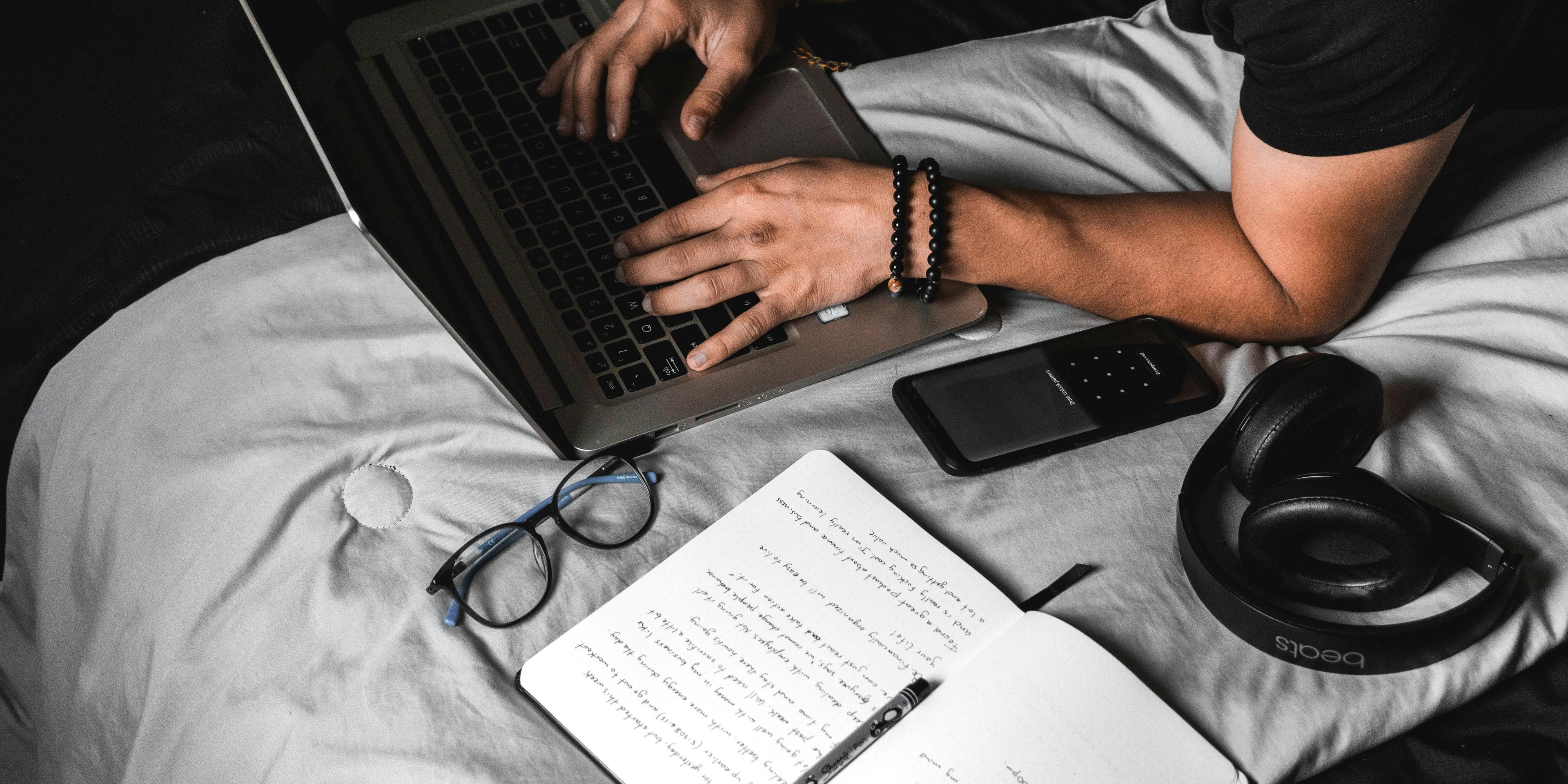 Student preparing for the Duolingo English Test using a laptop with notes and study materials