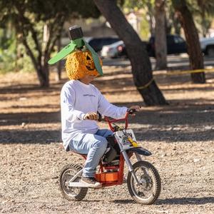 Pumpkin-head Carlos on mini-e-bike