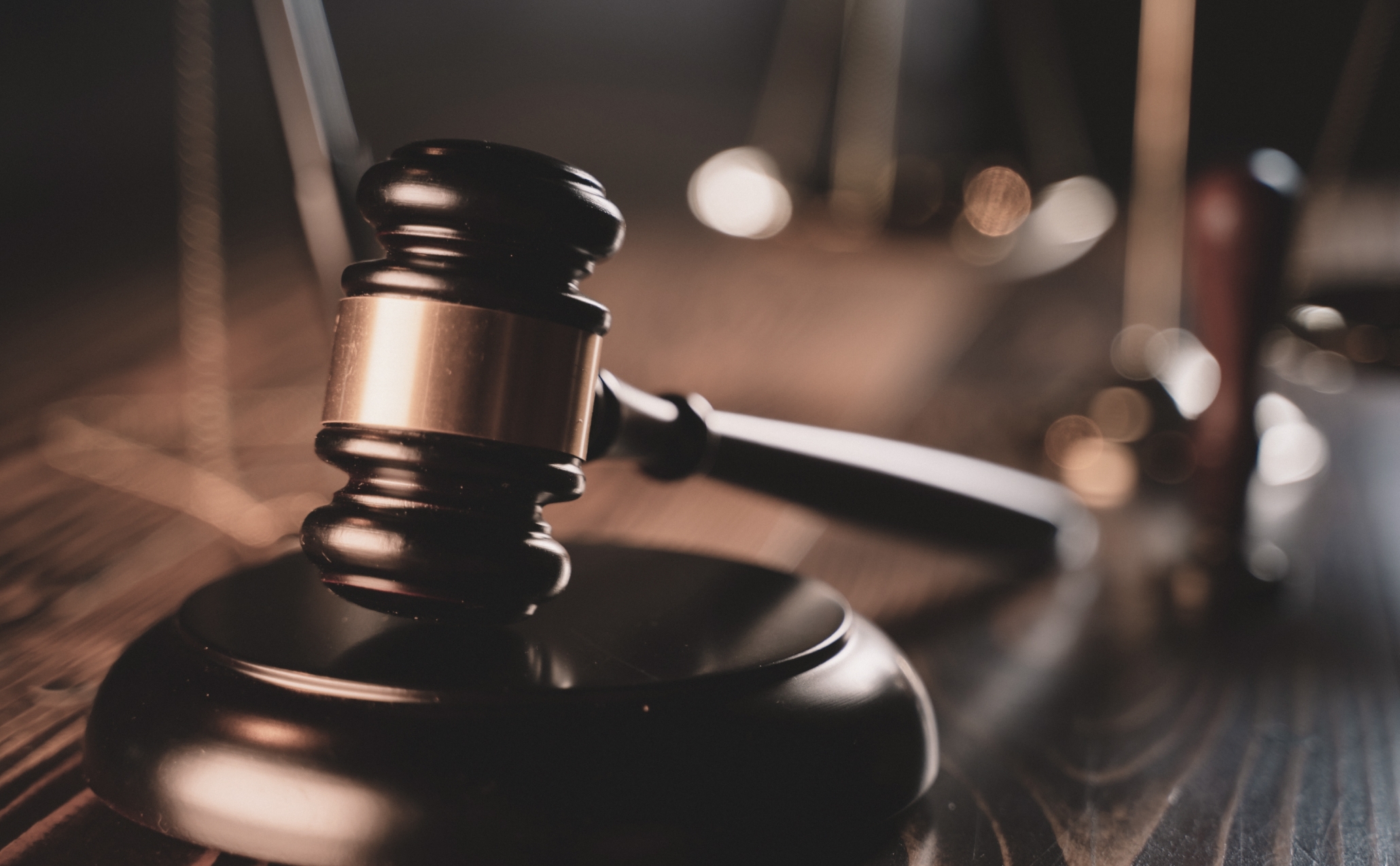A judge's gavel resting on a wooden desk