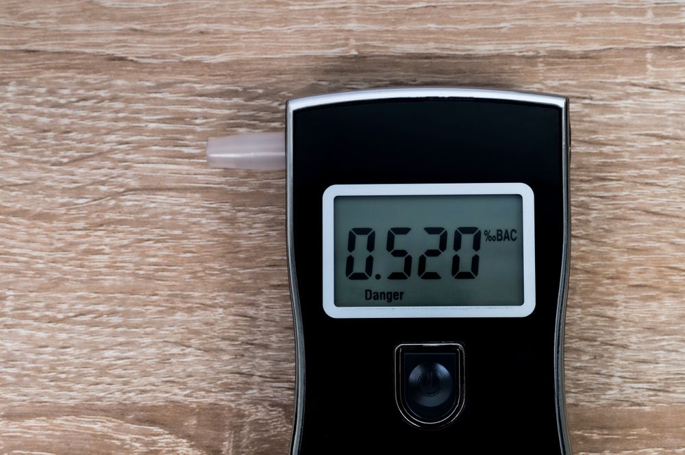 A handheld breathalyzer displaying a blood alcohol reading