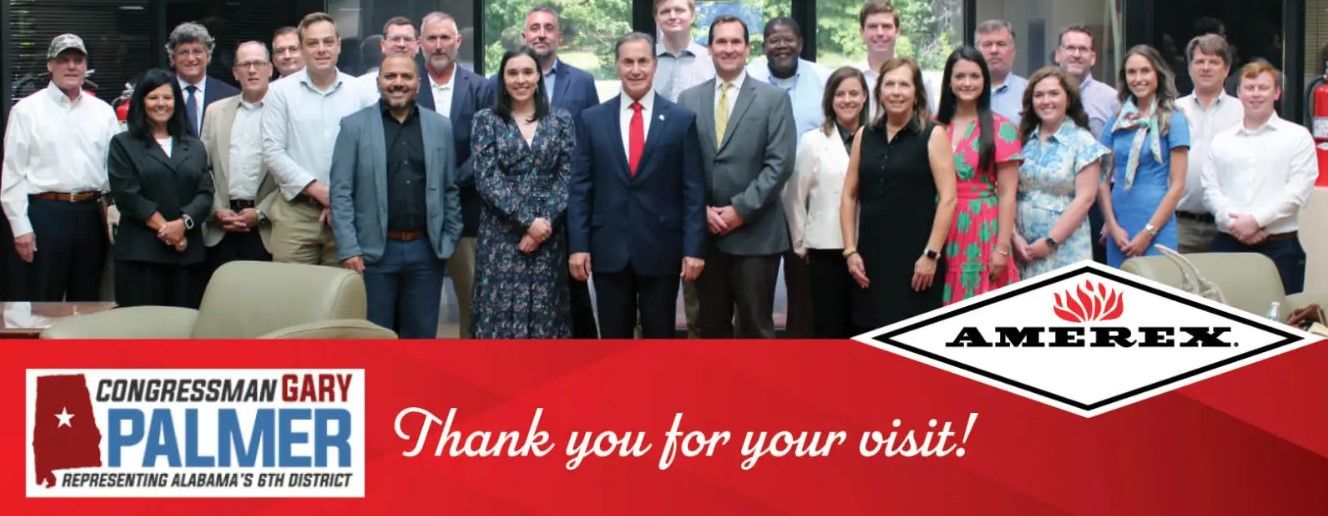 A group of people in business attire pose together indoors. In front, a banner reads, “Congressman Gary Palmer, Representing Alabama’s 6th District” and “Thank you for your visit!” with the Amerex logo.