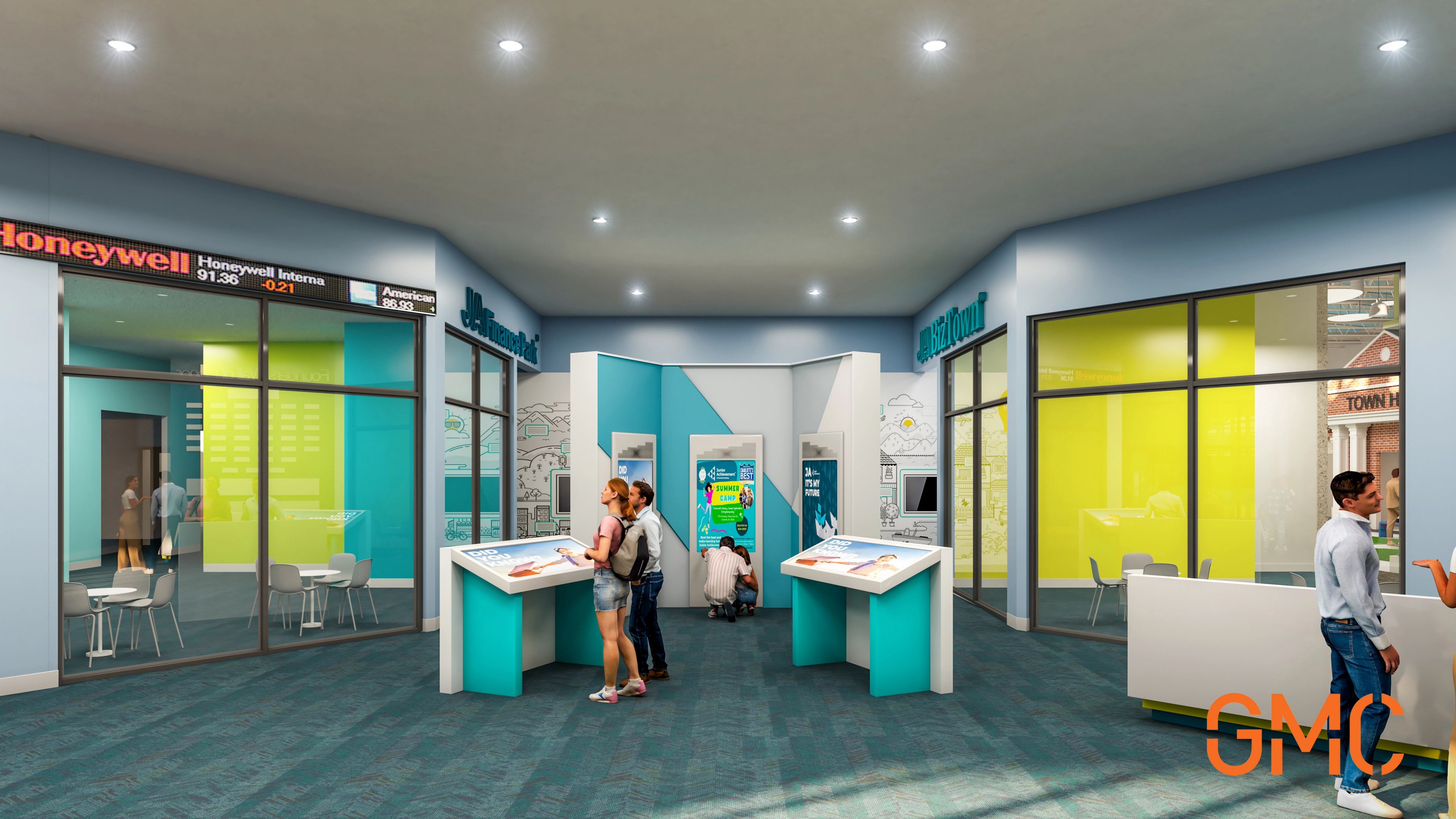 A modern, colorful lobby area with interactive kiosks, people engaging with displays, glass offices on the sides, and bright lighting. The floor is blue carpet and walls have signs reading “Honeywell” and “GMC.”.