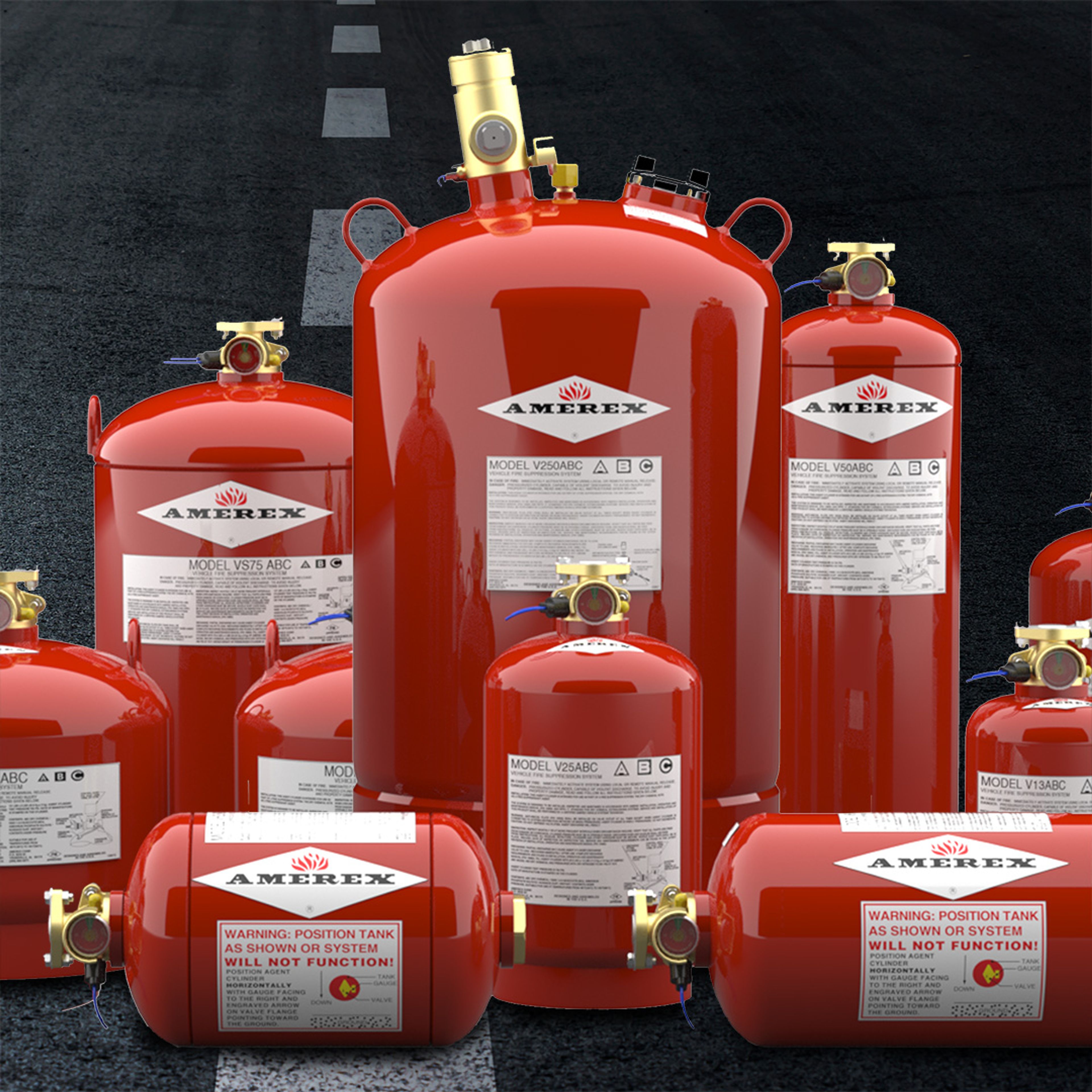 Several red AMEREX fire suppression tanks of various sizes are arranged on an asphalt road, with prominent white labels and brass valves. The labels contain warning and model information.