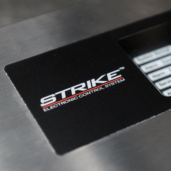 Close-up of a black panel with the white text “STRIKE Electronic Control System” in bold letters, part of a metal device.