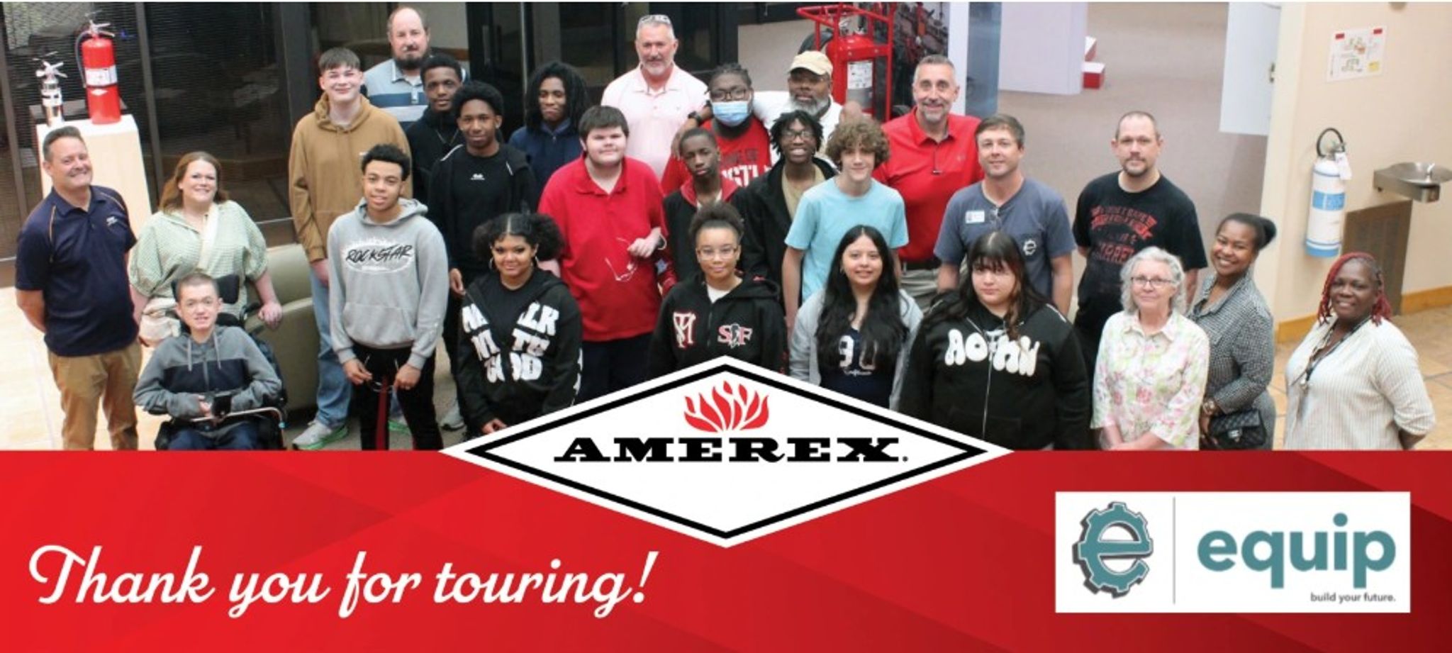A diverse group of people poses together indoors for a group photo, standing behind an “AMEREX” logo and banners reading “Thank you for touring!” and “equip build your future.”.