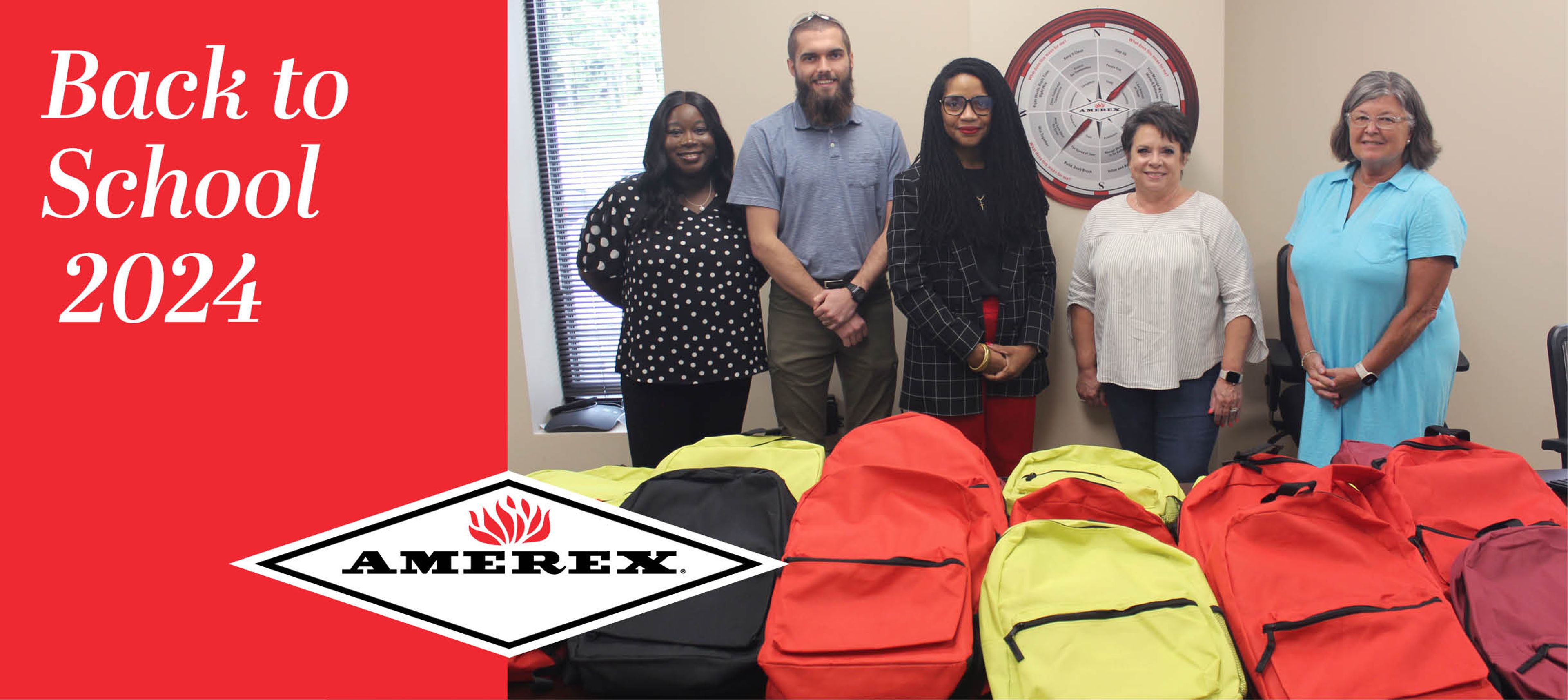 Five people stand behind tables with red and yellow backpacks. A sign reads “Back to School 2024” and the Amerex logo is visible. A window and a clock are in the background.