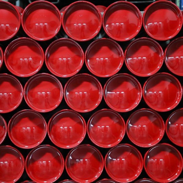 Rows of stacked, round, bright red cups viewed from above, forming a visually striking geometric pattern.