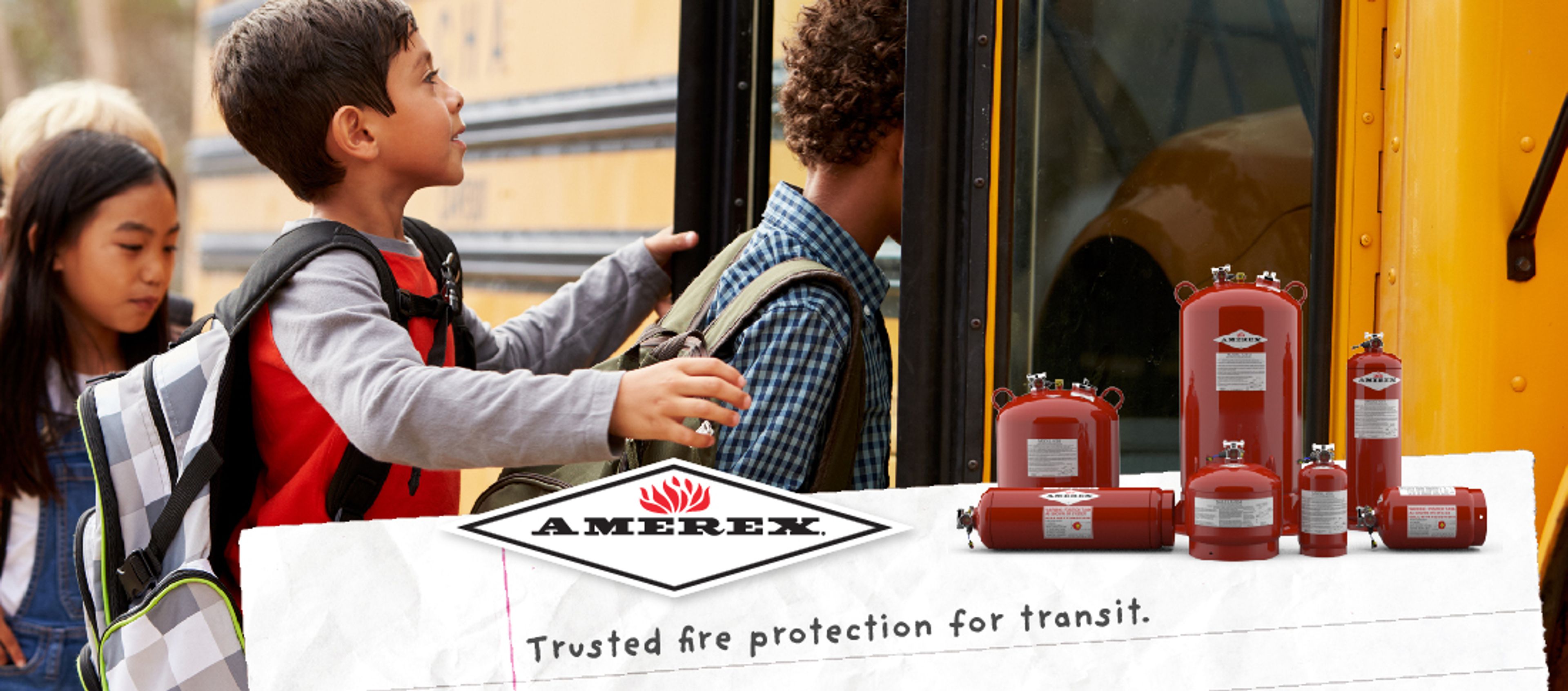 Three children board a yellow school bus. In the foreground, several red AMEREX fire extinguishers are displayed with the AMEREX logo and the text “Trusted fire protection for transit.”.