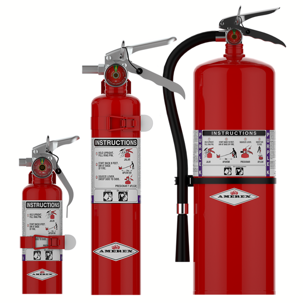 Three red fire extinguishers of different sizes are standing upright. Each has labels with instructions and handles; the largest extinguisher has a black hose attached.
