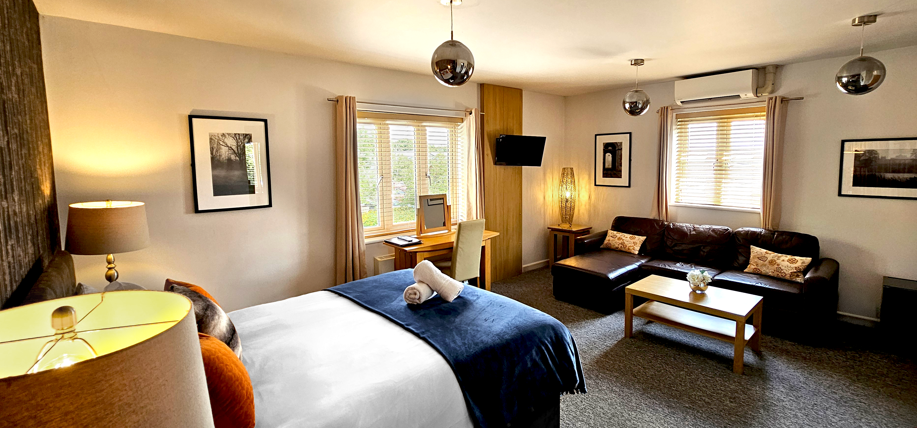 Deluxe room with double windows corner leather sofa, coffee table, desk & king size bed