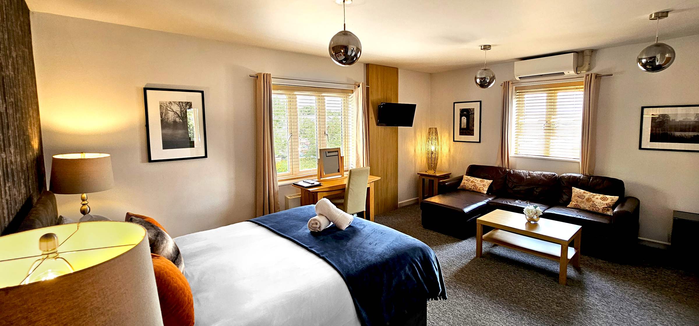 Deluxe room with double windows corner leather sofa, coffee table, desk & king size bed