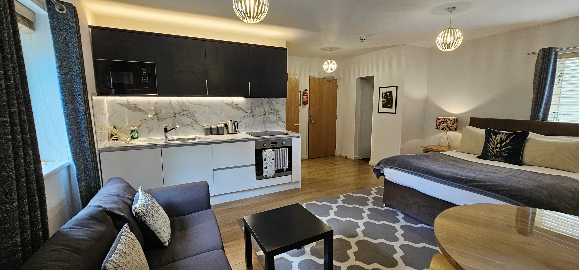 Studio Suite - kitchenette with oven, hob & microwave along with sofa, dining table & king size bed