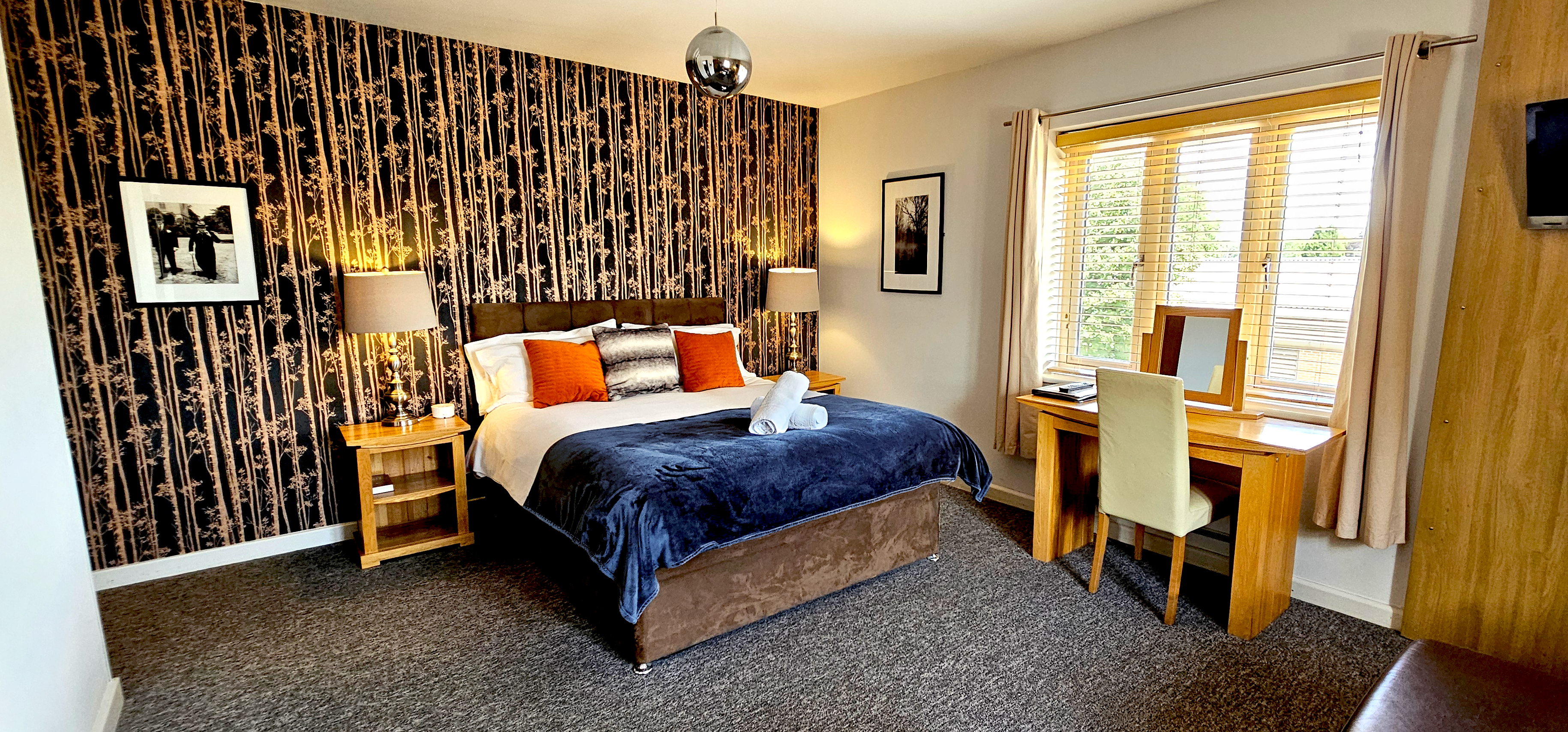 Large deluxe room with king size bed & writing desk & leather corner sofa