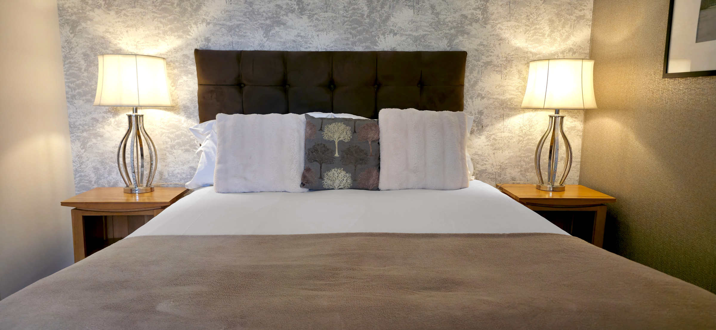 Extremely comfortable king size bed with side lamps in Studio Suite