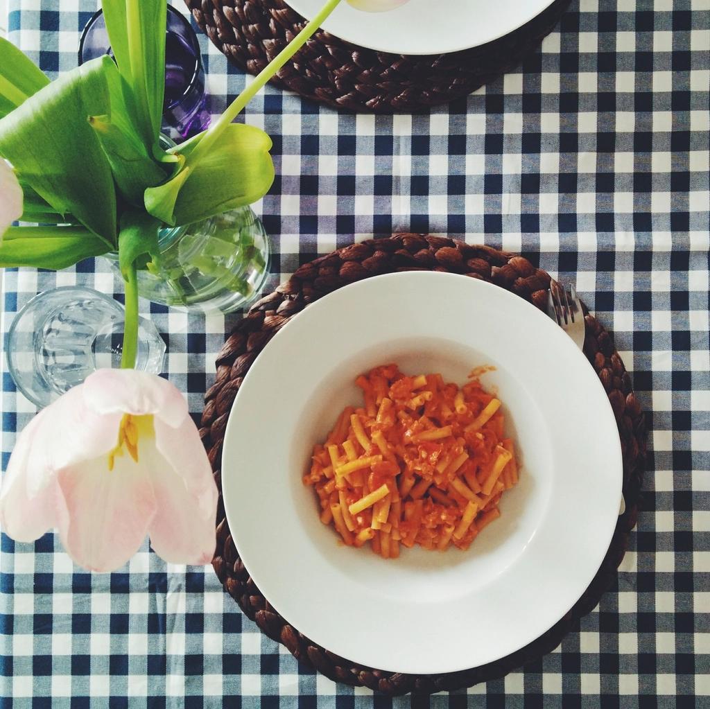 Teller Penne in Tomatensauce auf kariertem Tischtuch