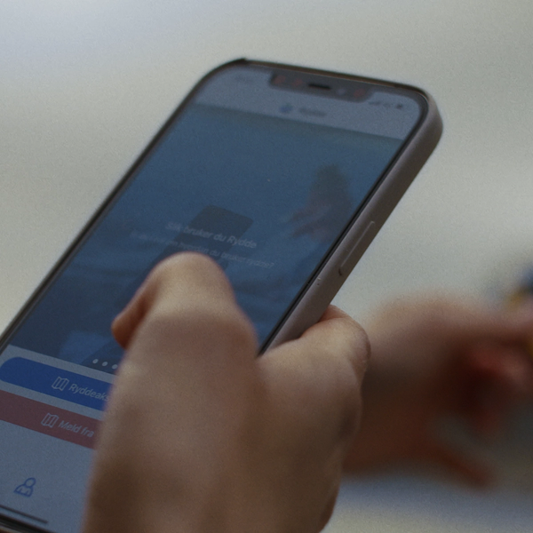 Hånd som holder en telefon med Rydde-app