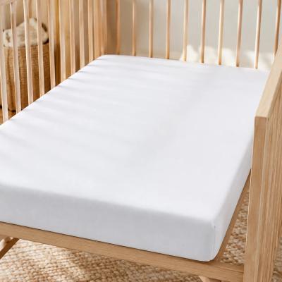 Bamboo fitted crib sheet on a bare crib mattress