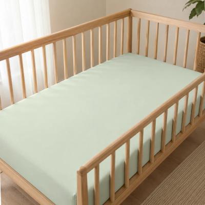 Bamboo fitted crib sheet on a bare crib mattress