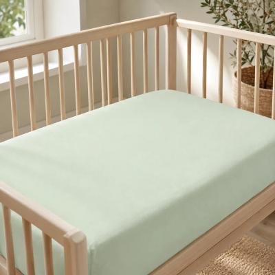 Bamboo fitted crib sheet on a bare crib mattress