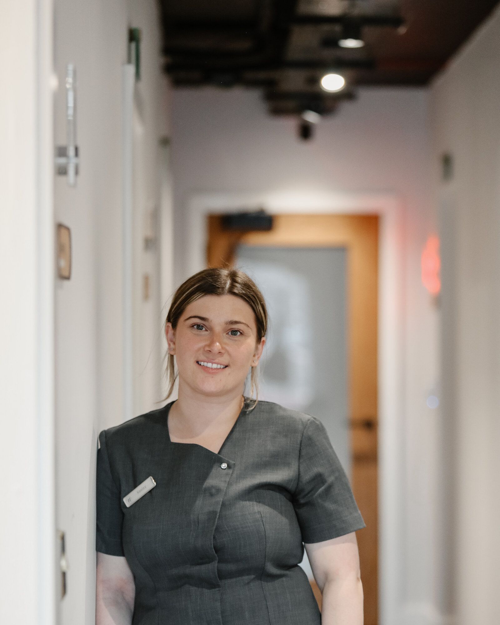 Team member smiling in a West End Dental practice corridor