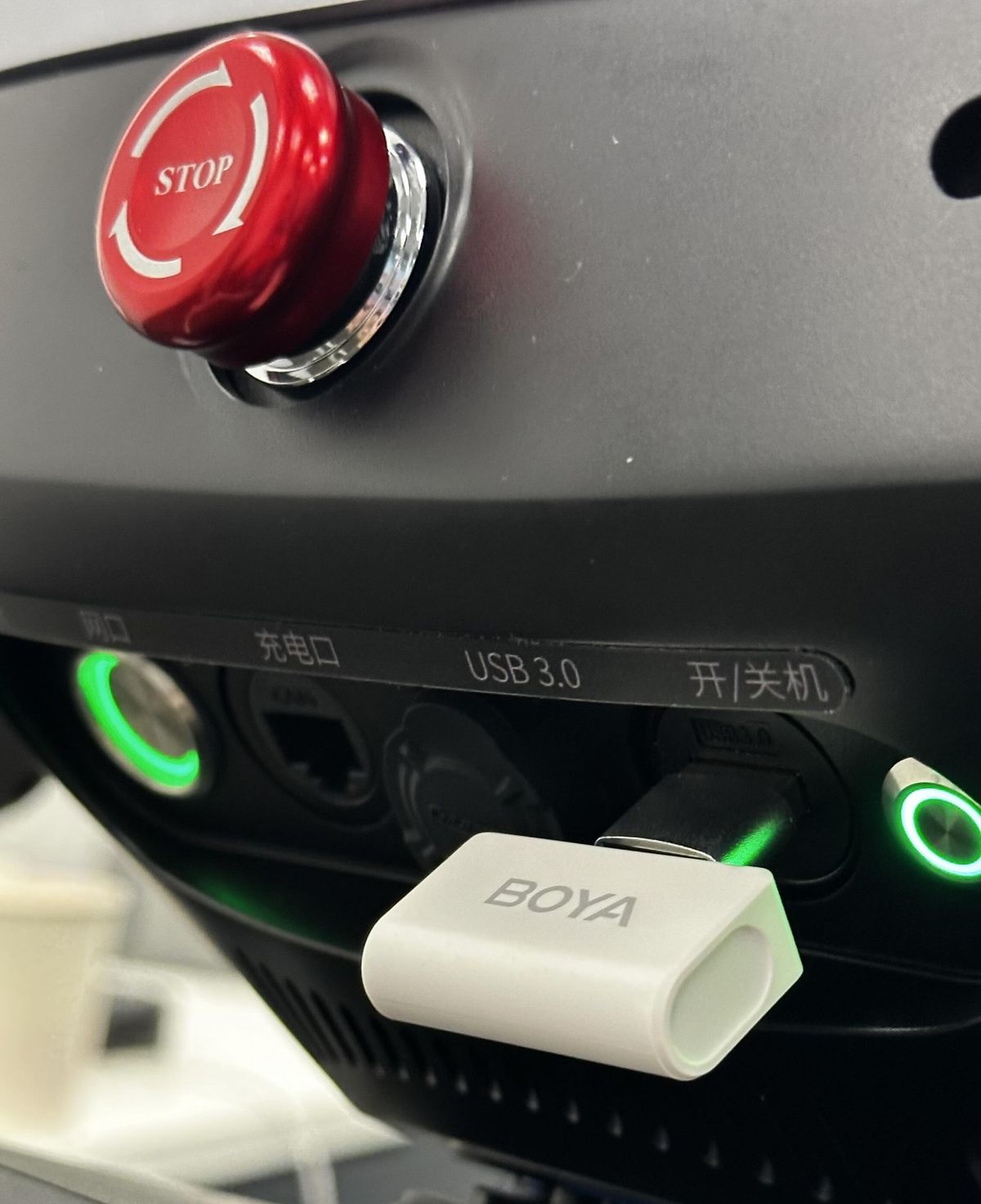 Приёмник беспроводного микрофона в штатном порту USB 3.0. Красная кнопка рядом — аварийный стоп; к голосовому пайплайну отношения не имеет, но во время отладки распознавания команд движения взгляд к ней возвращался регулярно.