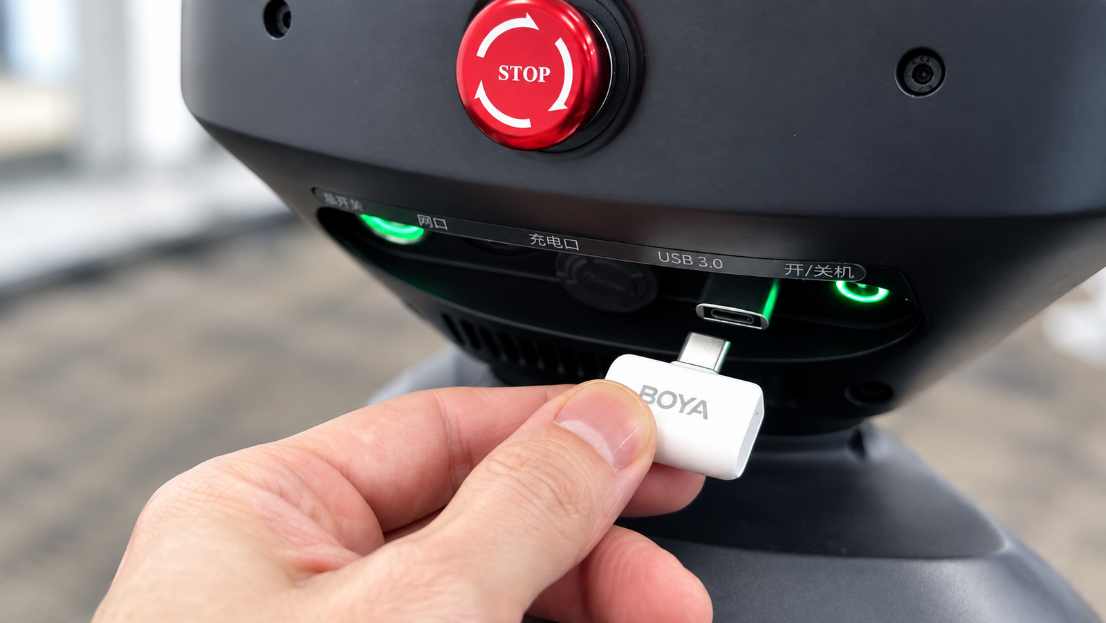 Рука отключает белый USB-приёмник беспроводного микрофона от панели робота.