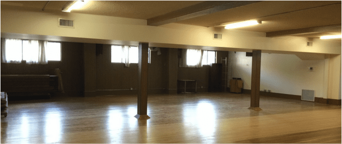The Downstairs Hall, an open wooden floor between painted posts