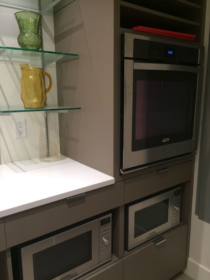 The end of the servery counter, with a microwave and a glass shelf