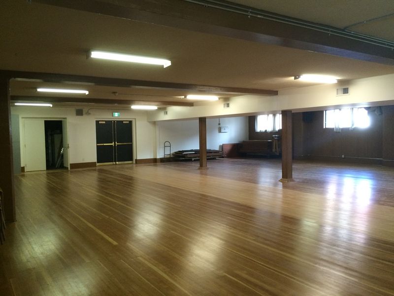 The Downstairs Hall, its wooden floor reflecting the window light